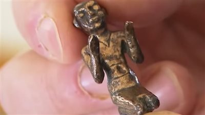 لحظة الكشف عن تمثال معدني من أسفل الرمال.. ما حكايته وإلى أي عصر يعود؟